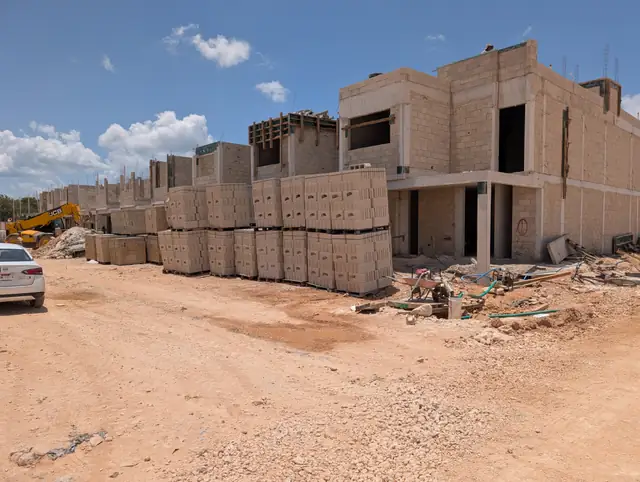 Tarimas de bloque apiladas junto a las viviendas en construcción de Jardines del Sur 7, Cancún